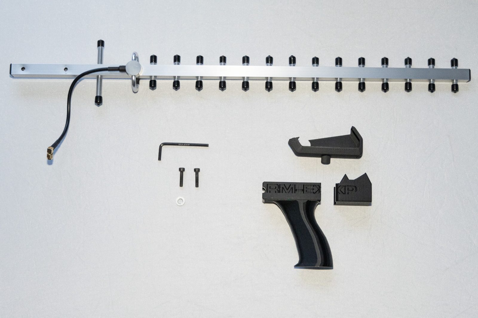 Every part laid out flat: boom, grip, mount, hardware and key